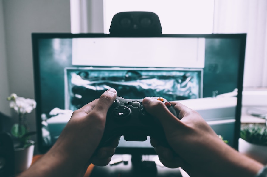 Computerspiele: Spieler vor einem Monitor beim spielen eines Autorennspiel